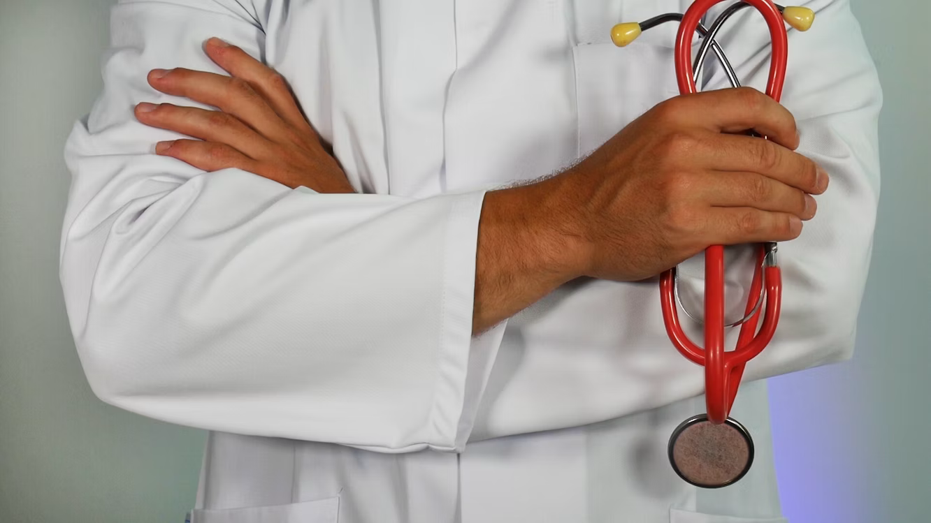 A doctor holding a red stethoscope