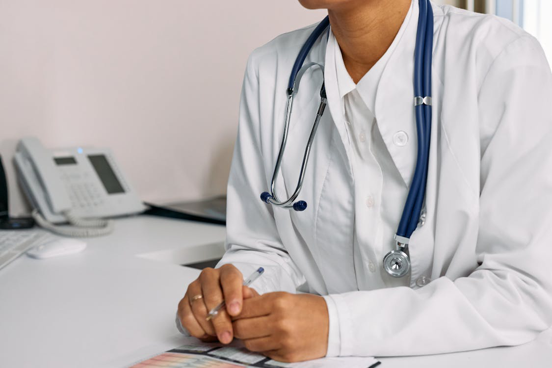 Doctor in a clinic office with a stethoscope and medical documents.